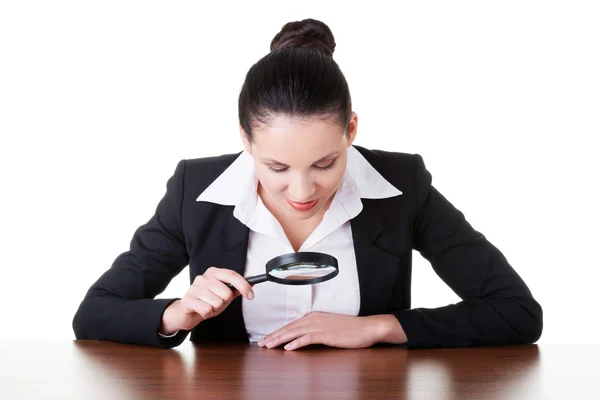 Business woman looking through magnifying glass on table. — Stock Photo, Image