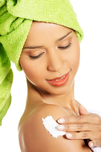 Mujer atractiva frotando una loción corporal en su brazo. Vista lateral . — Foto de Stock