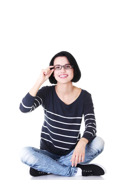 Attraktive Frau mit Brille im Schneidersitz. — Stockfoto