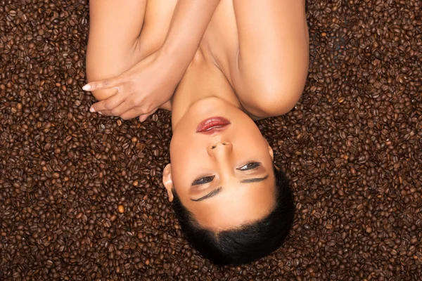 Atrakcyjna kobieta nogami leżąc na nasiona kawy. — Zdjęcie stockowe
