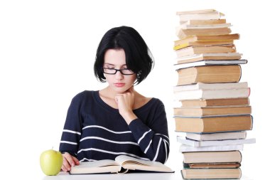 kitap yığınının yanında oturan arrtactive genç kadın