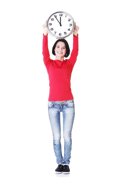 Attractive woman holding a clock above her. — Stock Photo, Image