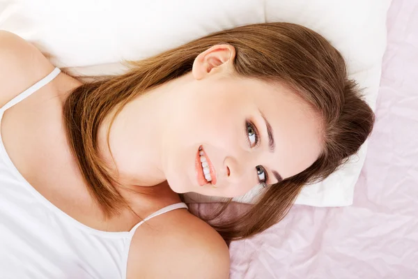 Mujer atractiva acostada en una cama . — Foto de Stock