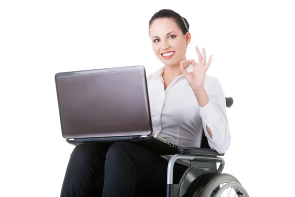 Femme d'affaires assise en fauteuil roulant, montrant OK . — Photo