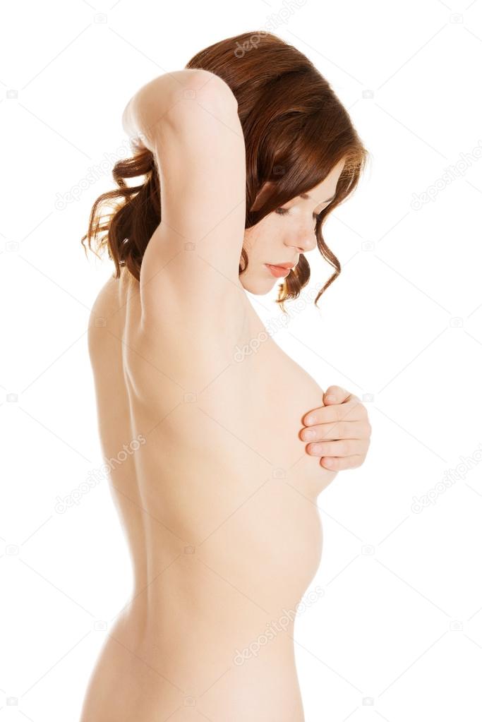 Attractive woman holding and examining her breasts.