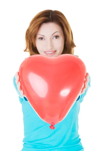 Attractive woman giving a baloon heart. — Stock Photo, Image