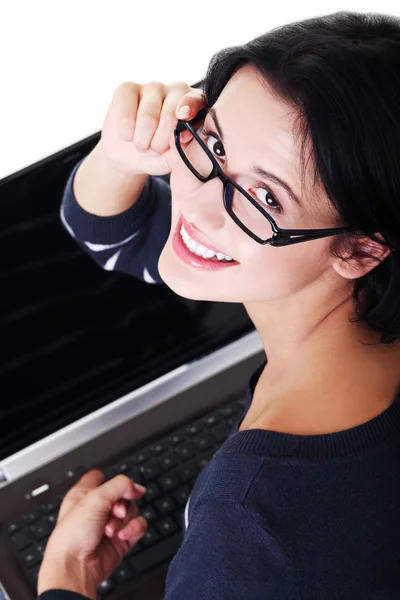 Ελκυστική νεαρή γυναίκα που κάθεται μπροστά από ένα φορητό υπολογιστή. — Φωτογραφία Αρχείου