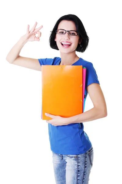 Mujer atractiva estudiante sosteniendo archivos y mostrando OK . —  Fotos de Stock