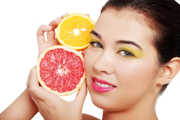 Gyönyörű nő arcát narancs és grapefruit. — Stock Fotó