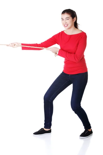 Attractive young woman puuling a rope. — Stock Photo, Image