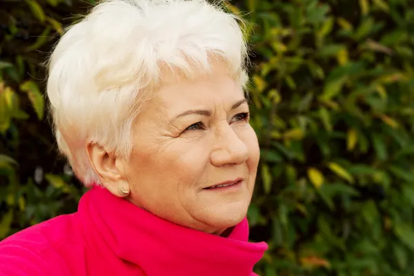 Portrait of a cheerful old lady over green background. — Stock Photo, Image