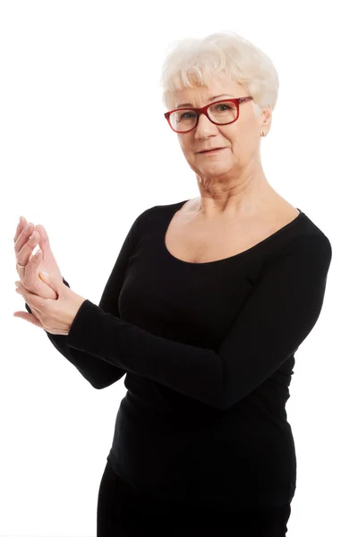 An old lady massaging her hands, palms. — Stock Photo, Image