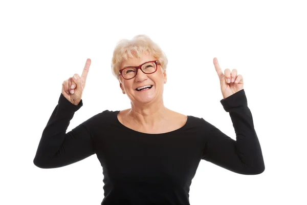 Una anciana feliz señalando un espacio de copia . —  Fotos de Stock