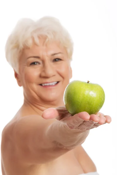 Nude old woman holding and apple. — Stock Photo, Image