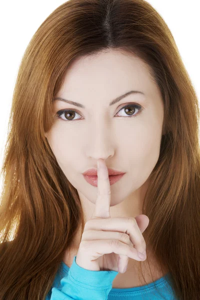 Porträt einer lässigen Frau mit dem Finger auf den Lippen. — Stockfoto