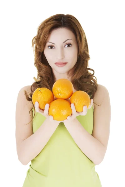 Mulher casaual atraente segurando laranjas . — Fotografia de Stock