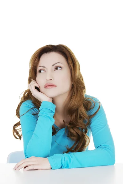 Attractive casual woman sitting and looking up. Royalty Free Stock Photos