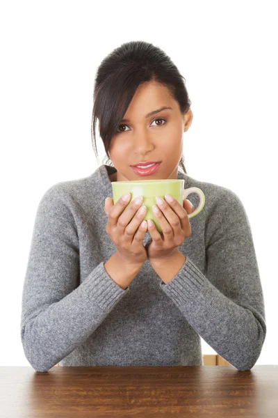 Mujer joven bebiendo algo de una taza grande — Foto de Stock