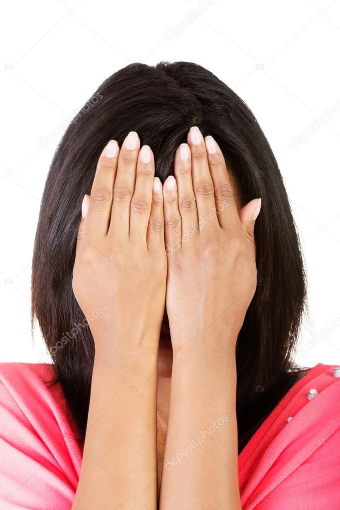 Young teen woman covering her face with hands