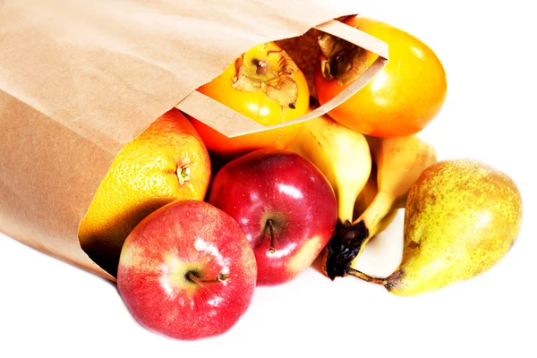 Apples,kaki and pears lying on the floor in paper bag. — Stock Photo, Image