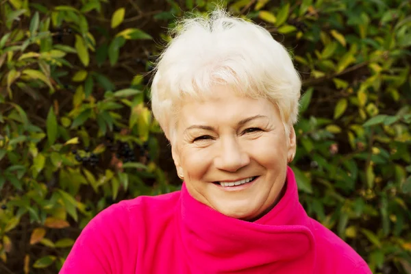 Portret van een oude vrouw stond in de tuin. — Stockfoto