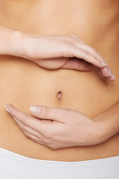 Close up on woman's hands touching hher belly. — Stock Photo, Image