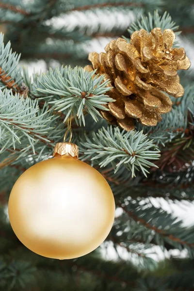 Weihnachtskugel und Zapfen überreichen einen Baum. — Stockfoto