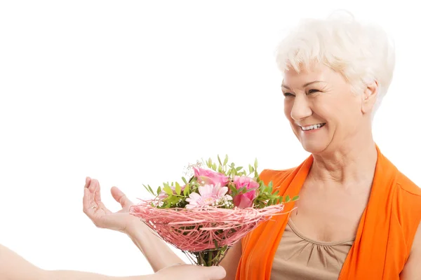 Uma mulher velha com buquê de flores . — Fotografia de Stock