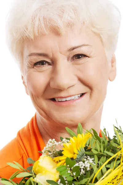 Een oude vrouw met boeket van bloemen. — Stockfoto