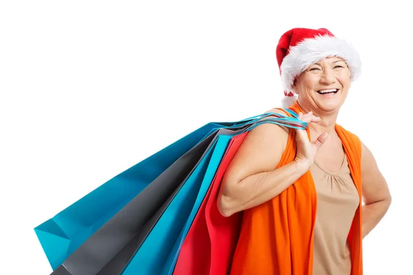 An old woman holding presents,bags in santa hat. — Stock Photo, Image