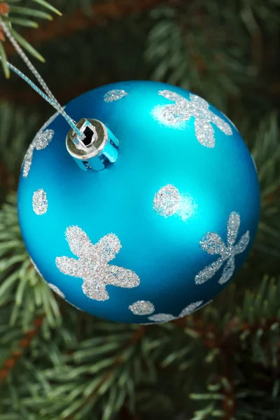 Eine blaue Weihnachtskugel überreicht einen Baum. — Stockfoto