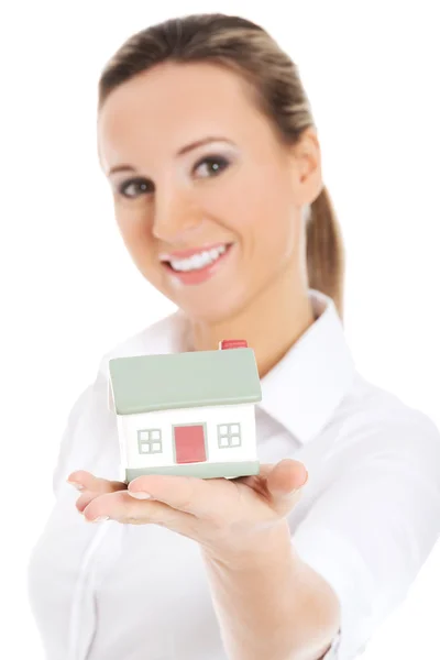 Young business woman holding a house on her palm. — Stock Photo, Image