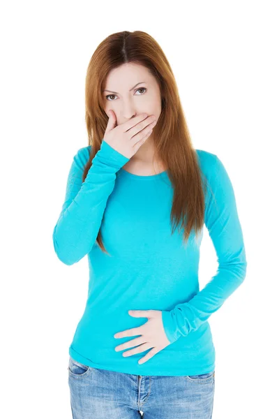Attractive casual woman with hand on mouth and belly. — Stock Photo, Image