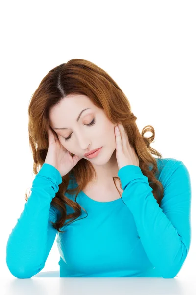 Attractive casual woman sitting and holding her neck — Stock Photo, Image