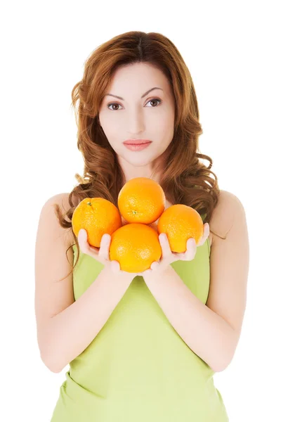 Aantrekkelijke casaual vrouw bedrijf sinaasappelen. — Stockfoto