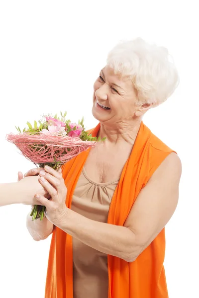 An old woman with bouquet of flowers. Stock Picture