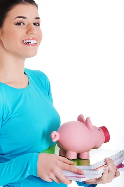 Casual student woman holding workbook and piggy-bank. — Stock Photo, Image