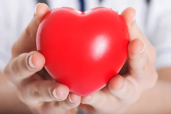 Red heart held by a female doctor. — Stock Photo, Image