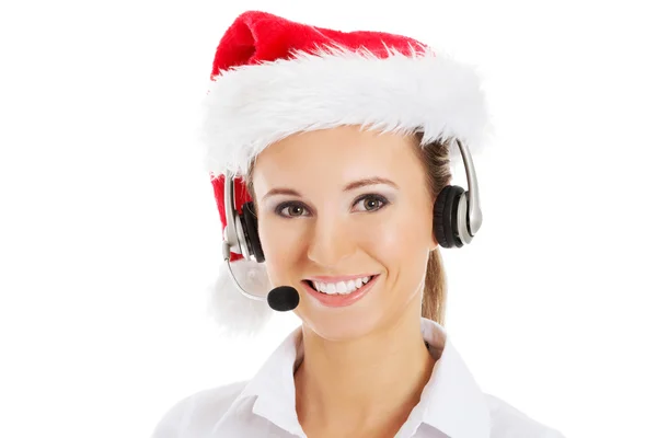 Giovane donna d'affari in cappello di Babbo Natale, microfono e cuffie . — Foto Stock