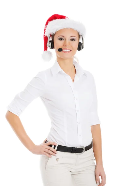 Junge Geschäftsfrau mit Weihnachtsmütze, Mikrofon und Kopfhörer. — Stockfoto