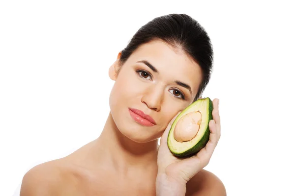 Beautiful woman's face with avocado. — Stock Photo, Image