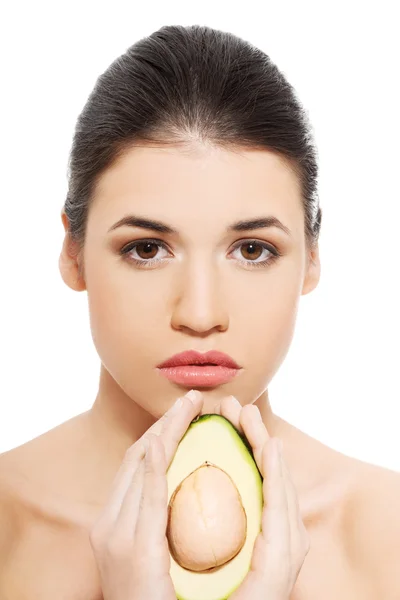 Beautiful woman's face with avocado. — Stock Photo, Image