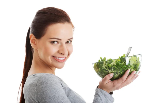 Junge ungezwungene Frau isst Feldsalat. — Stockfoto
