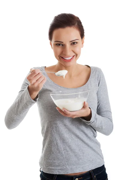 Junge Gelegenheitsfrau isst einen Joghurt. — Stockfoto