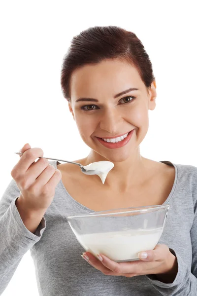 Junge Gelegenheitsfrau isst einen Joghurt. — Stockfoto