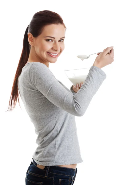 Casual jongedame eten een yoghurt. — Stockfoto