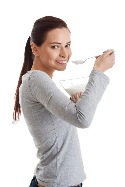 Mladá neformální žena jíst jogurt. — Stock fotografie