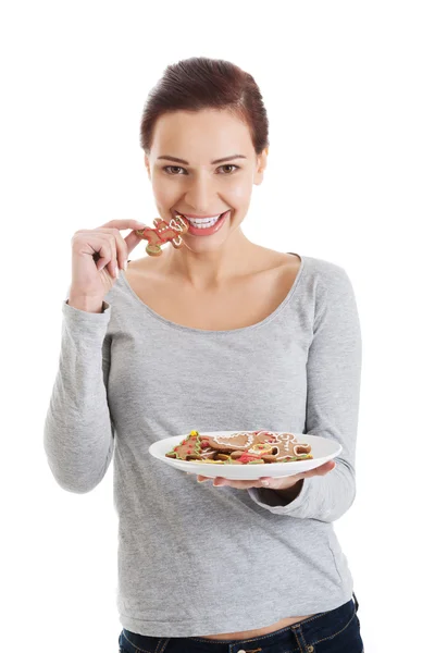 Vacker ung kvinna med cookies på en tallrik. — Stockfoto