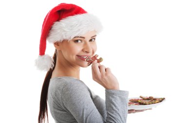 Noel Baba şapkası kurabiye yemek, güzel bir kadın.