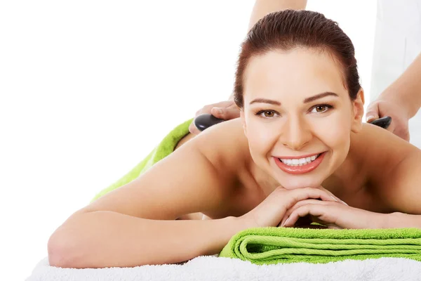 Beautiful woman lying on spa salon having stone massage. — Stock Photo, Image